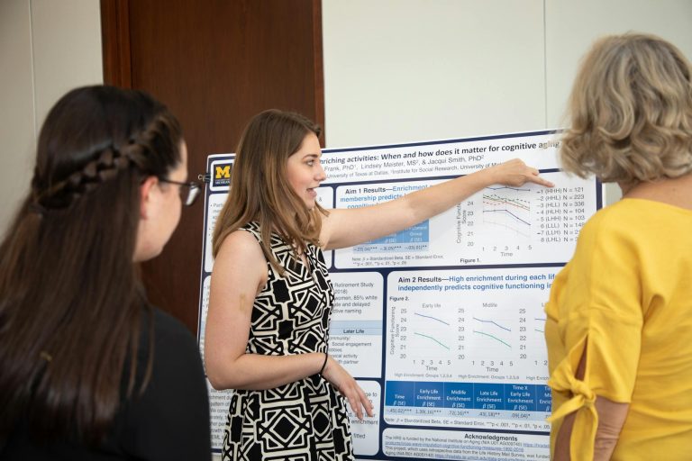 Researcher explaining cognitive science poster to peers, emphasizing scientific collaboration.